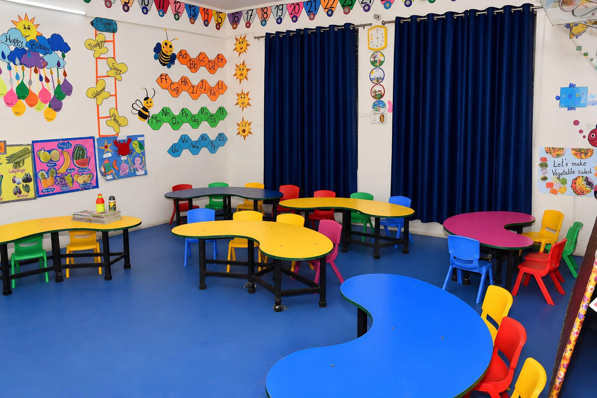 The youngest children's room, with curved tables, small chairs and a blue floor