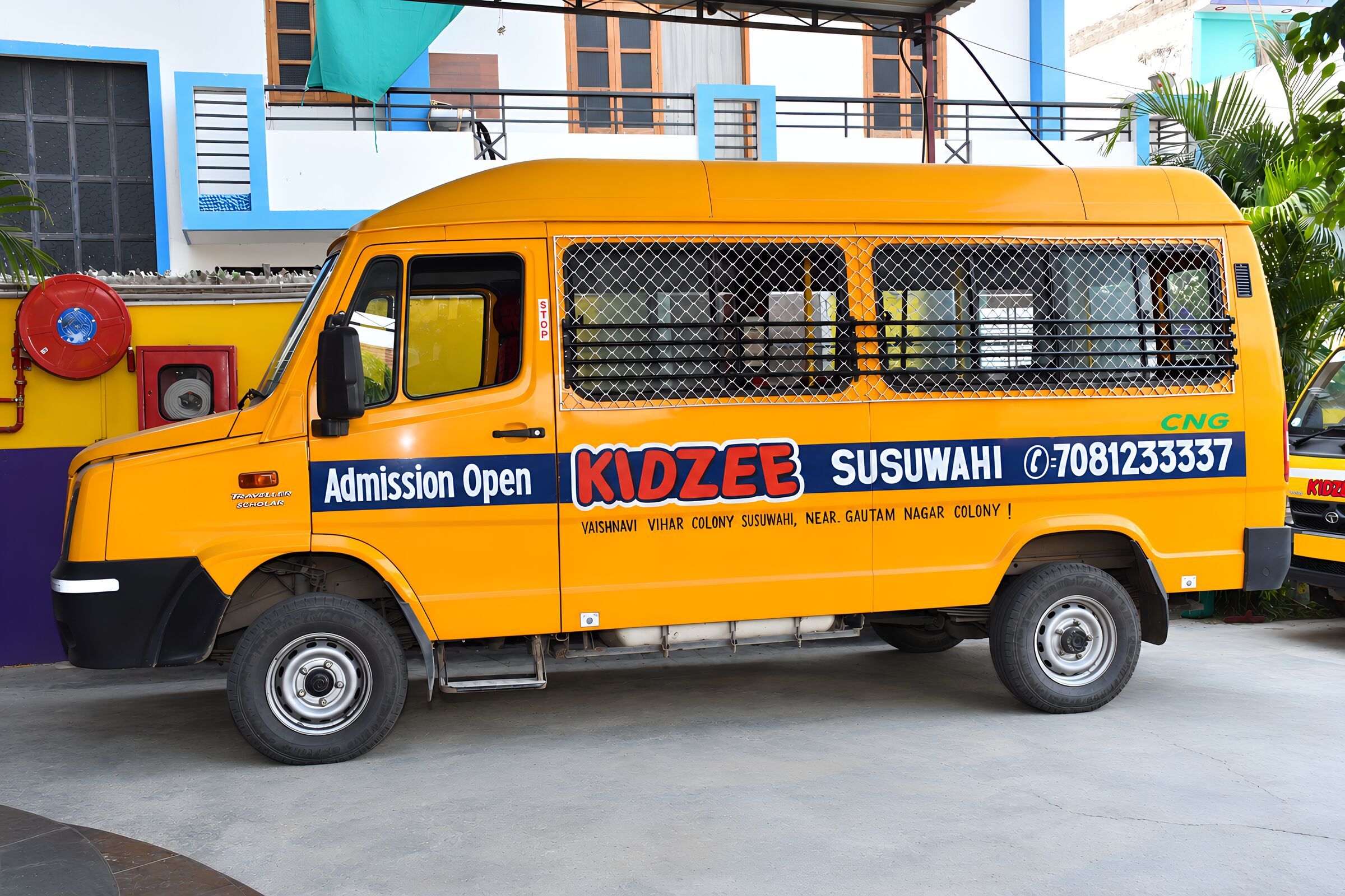 A yellow school van from the side, with the school's name on it