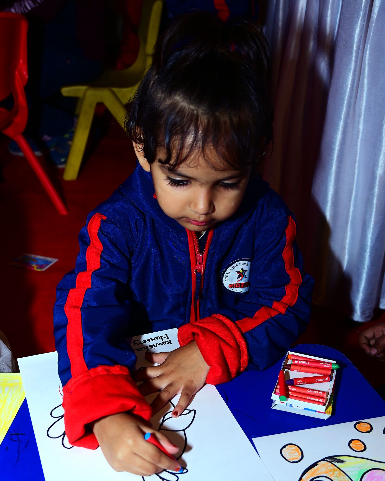A child colouring a drawing at a table